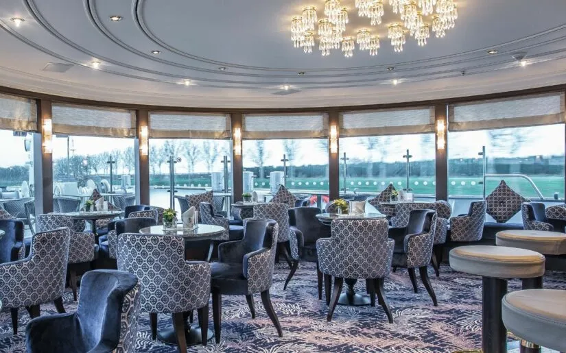 Panoramasalon der MS Moments mit Ausblick auf die Hafeneinfahrt.