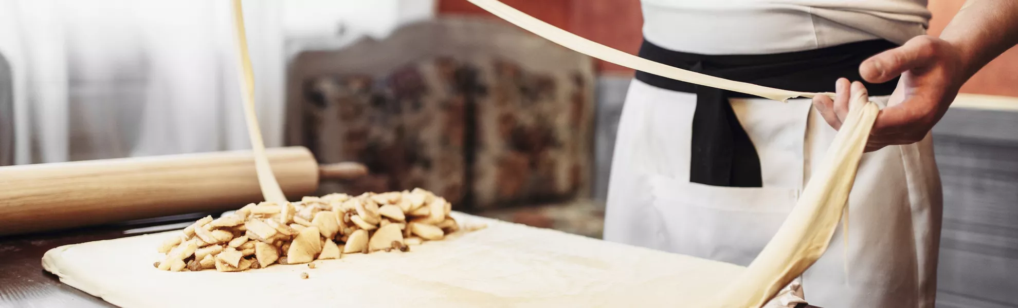 Male chef prepares dough for apple strudel