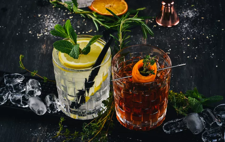 © Yaruniv-Studio - stock.adobe.com - zwei alkoholische Cocktails auf schwarzem Tisch