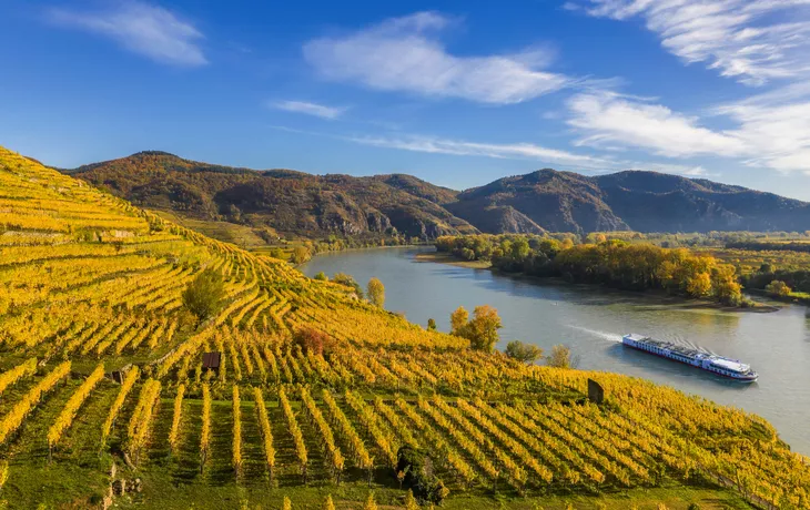 © Tomas Marek - stock.adobe.com - Herbstpanorama des Wachautals (Unesco-Weltkulturerbe) mit Schiff auf der Donau in der Nähe des Dorfes Weißenkirchen in Niederösterreich