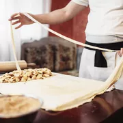 Male chef prepares dough for apple strudel