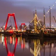 Am frühen Morgen im Alten Hafen, mit historischen Lastkähnen, der Willemsbrücke und der Fassade des „Weißen Hauses“ von Rotterdam