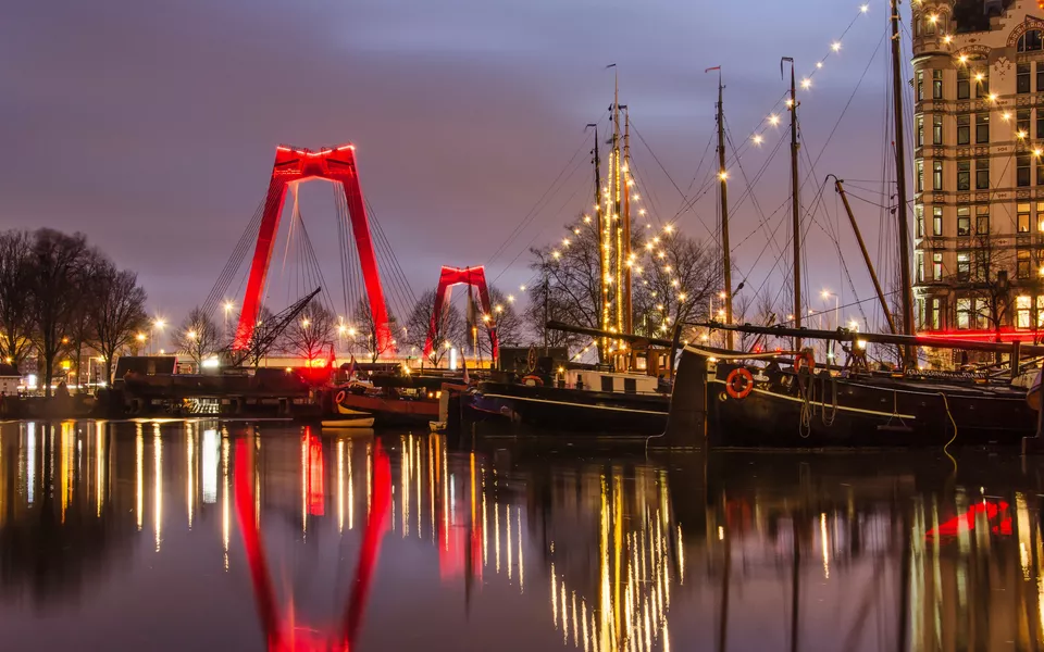 Am frühen Morgen im Alten Hafen, mit historischen Lastkähnen, der Willemsbrücke und der Fassade des „Weißen Hauses“ von Rotterdam