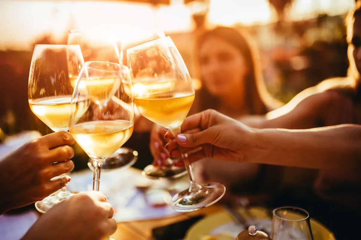 Menschen, die auf der Sommerterrasse eines Cafés mit Weingläsern anstoßen  - © minastefanovic - stock.adobe.com