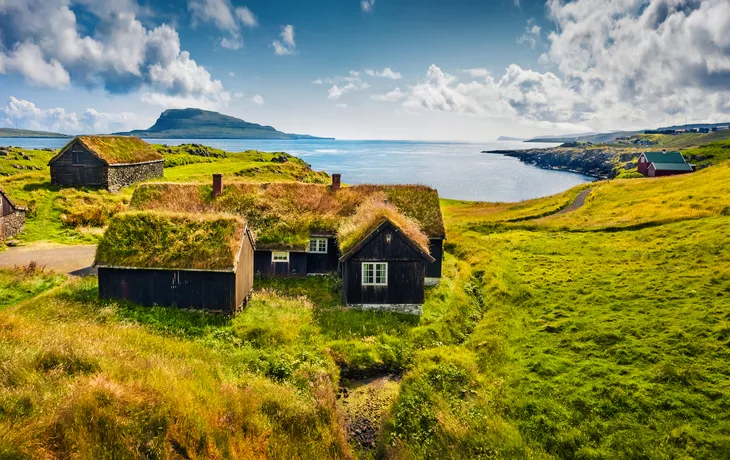 Sonniger Morgenblick auf typische Häuser mit Grasdach in der Umgebung von Torshavn, Hauptstadt der Färöer-Inseln - © Andrew Mayovskyy - stock.adobe.com
