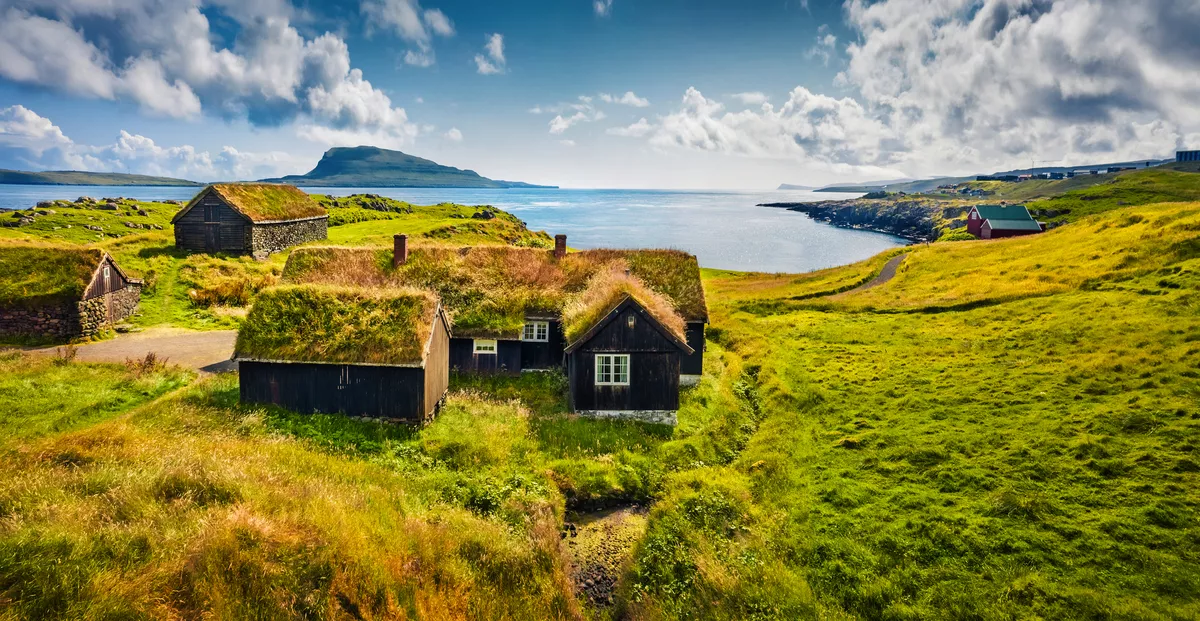 Sonniger Morgenblick auf typische Häuser mit Grasdach in der Umgebung von Torshavn, Hauptstadt der Färöer-Inseln - © Andrew Mayovskyy - stock.adobe.com