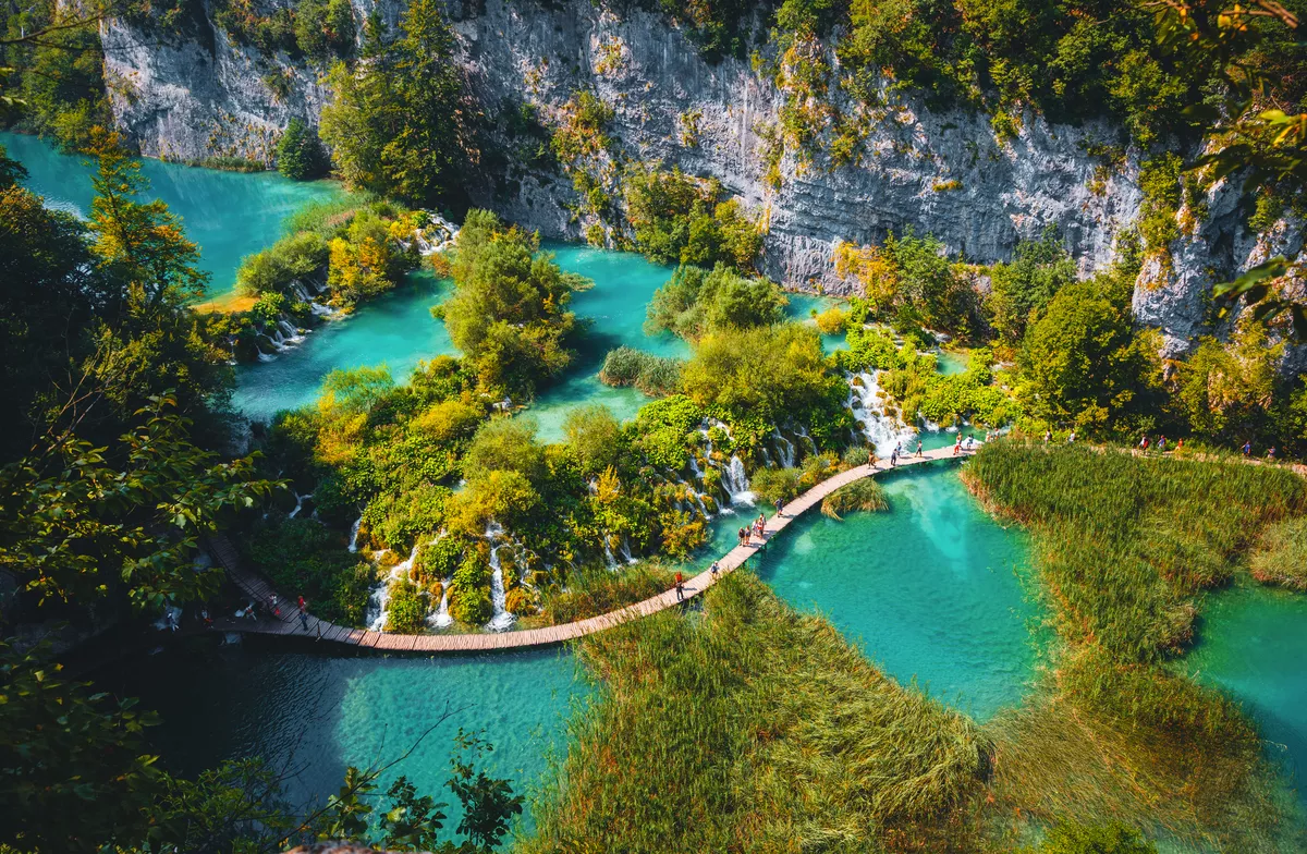 Luftaufnahme eines hölzernen Wanderwegs neben Wasserfällen im Nationalpark Plitvicer Seen - © Leonid Tit - stock.adobe.com